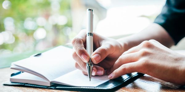 Woman's  hands writing in a journal