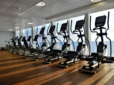 Row of cross trainers, treadmill and cycles in a gym