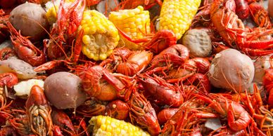 A vibrant seafood boil with crawfish, corn, and potatoes.