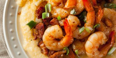 Shrimp and grits garnished with green onions and bacon bits.