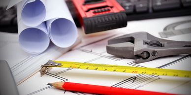 Architectural blueprints with measuring tools and a pencil on a desk.