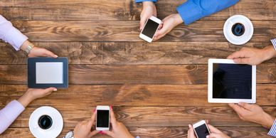 Group of people all with different cell phones or tablets