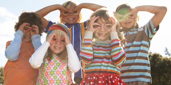 Children making glasses around their eyes with their hands
