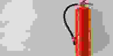 A red fire extinguisher hanging on a wall
