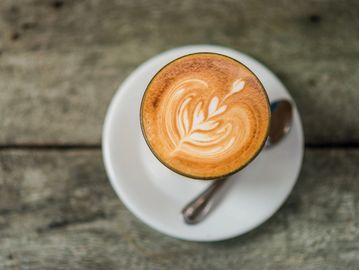 a cup of latte sitting on table