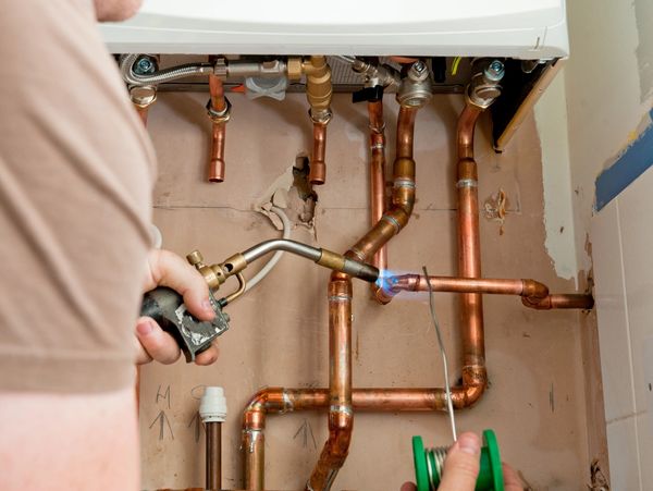 Using a blowtorch to solder copper pipes.