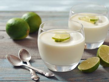 Two glasses of creamy lime dessert garnished with lime slices.