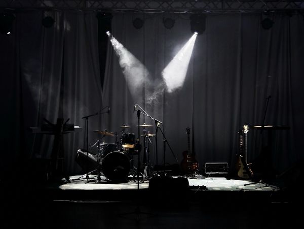 Empty stage with instruments under spotlights.
