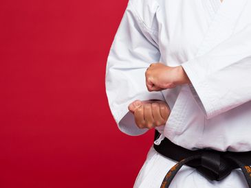 Karate practitioner in uniform performing a pose.