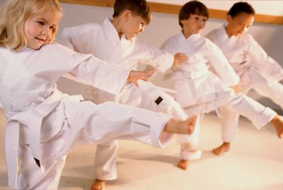 Toddlers on white outfit playing karate