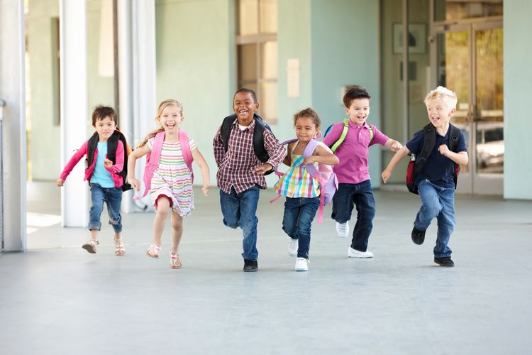 Young school children laughing and running
