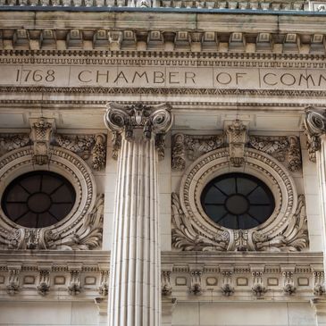 Ornate classical building facade with columns and round windows.
