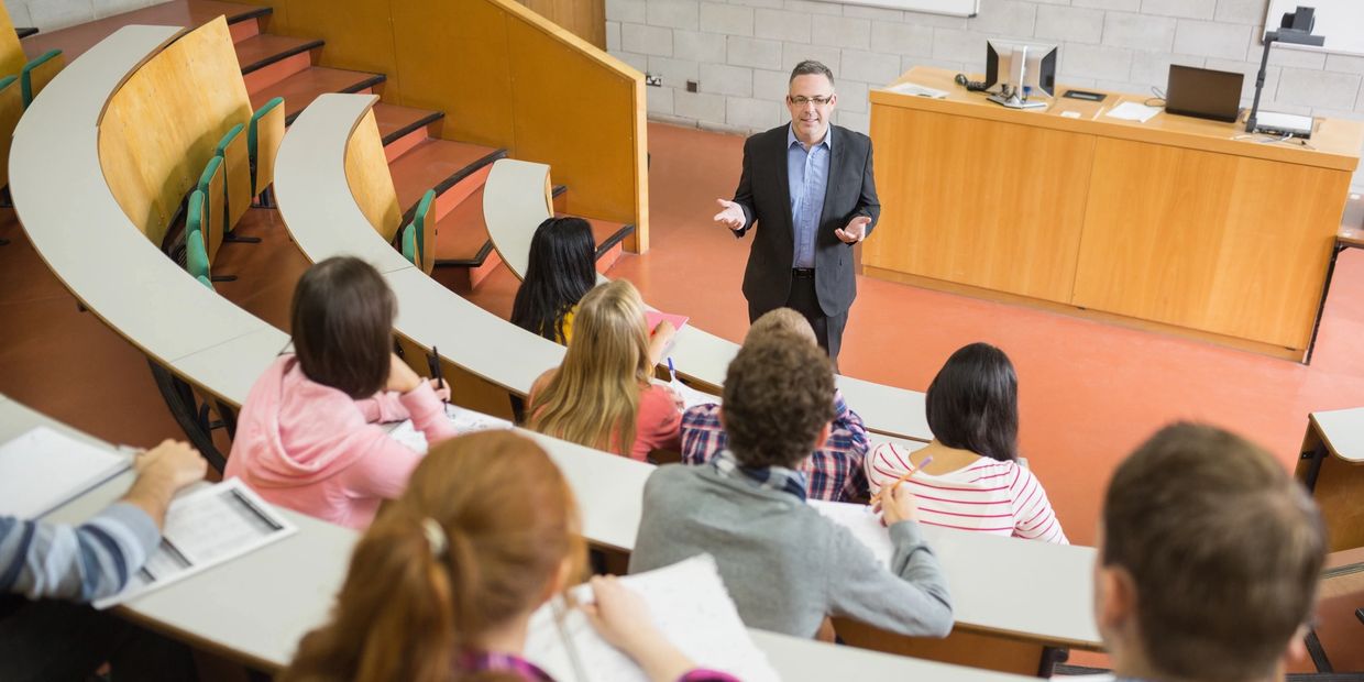 University professor lecturing students in a classroom.