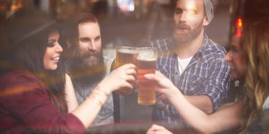 Beer Ambassadors meeting in a bar environment and toasting their beers mix of men and women 