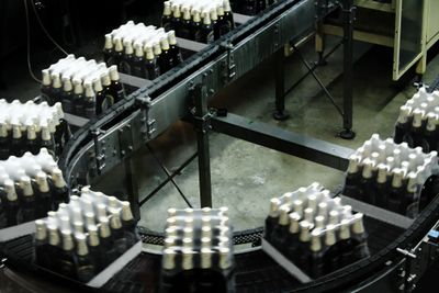 Conveyor belts transporting packaged bottles in a factory setting.