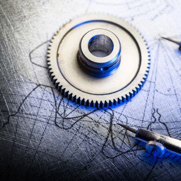 Metal gear and compass on technical blueprint.