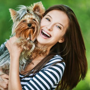 A women holding a small dog. Chiropractic care for women and pets.. 