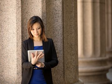 Photo of woman standing looking at a tablet