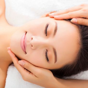 Woman enjoying a relaxing facial massage with closed eyes.