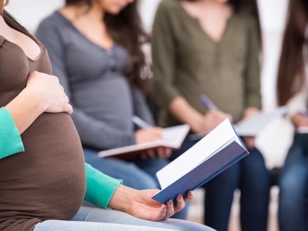 Childbirth Education Class with students reading their manual.