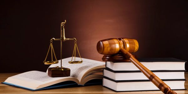 gavel laying on books held open by scales