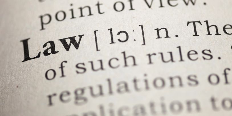 Close-up of the word 'Law' in a dictionary with pronunciation and definition.