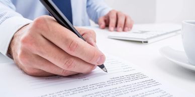 Man signing a document with a black pen