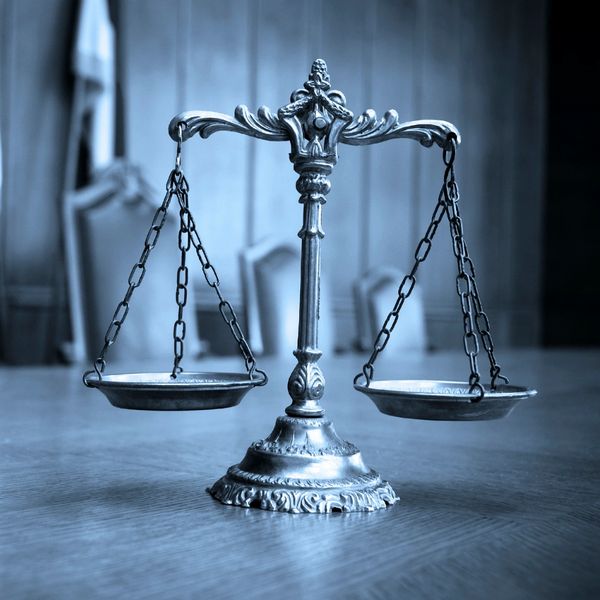 Antique justice scale on wooden table.