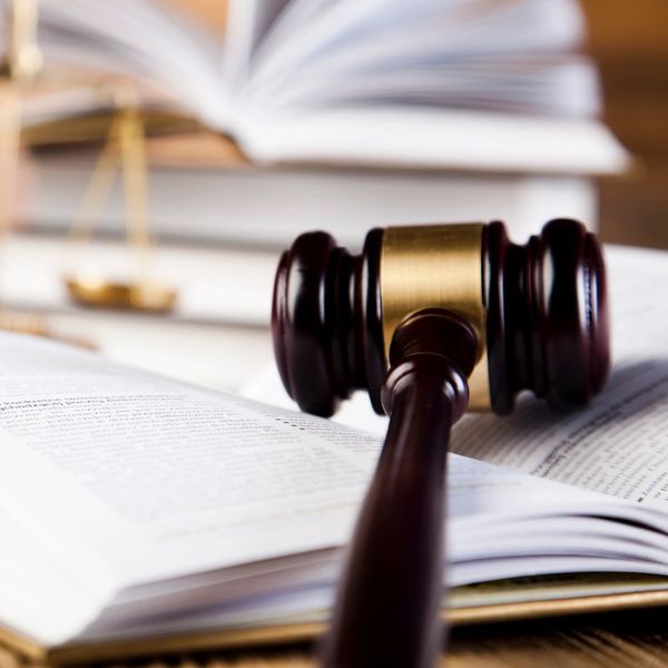 Libro abierto y sobre el hay un mazo de justicia 