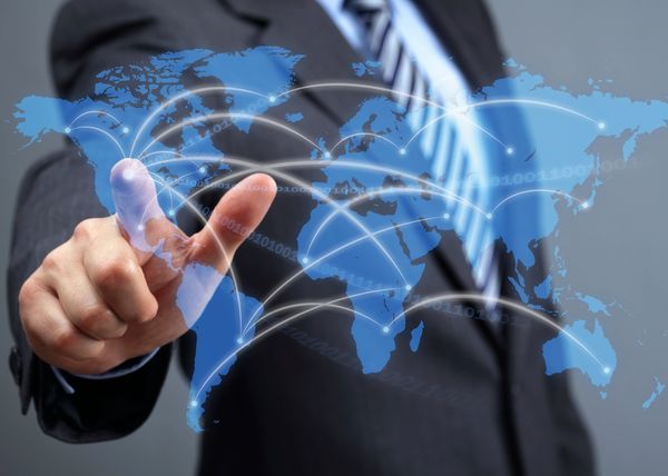 Businessman interacting with a digital world map showing global connections.