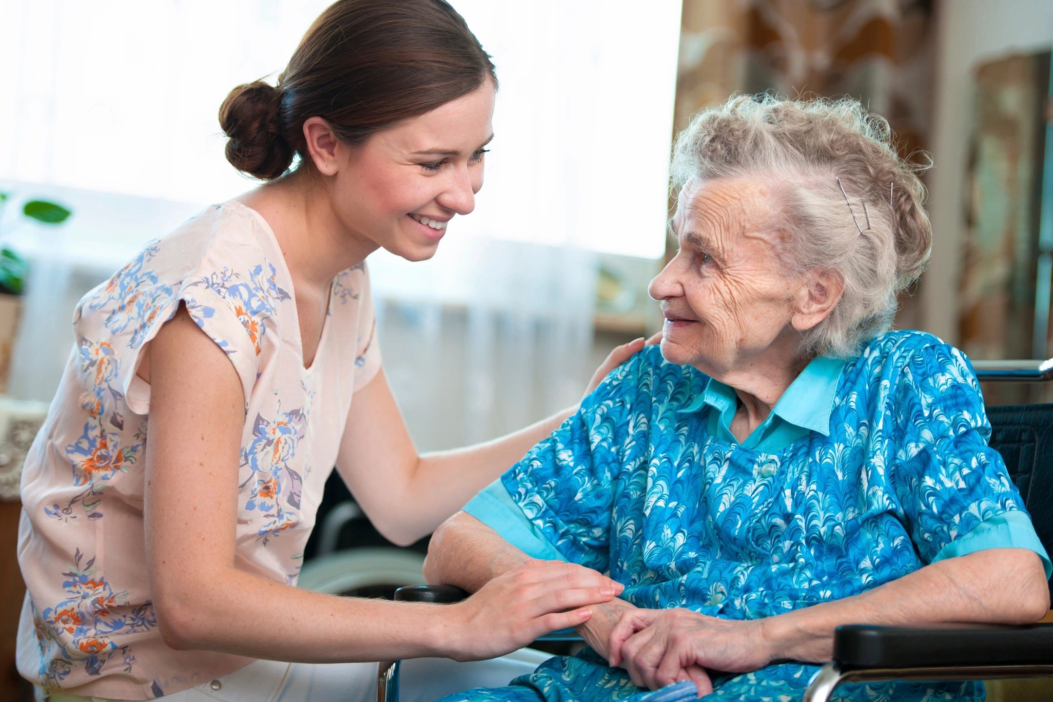 Elder woman with caretaker at home.