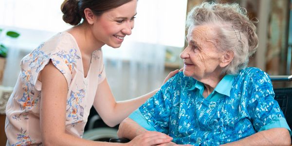 A caretaker taking personalized care of a senior woman