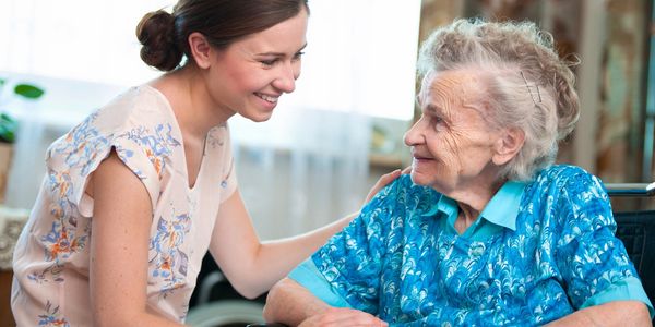 a smiling woman helping a lady