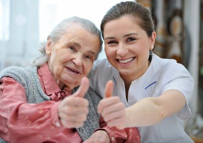 older women and younger women smiling and giving a thumbs up