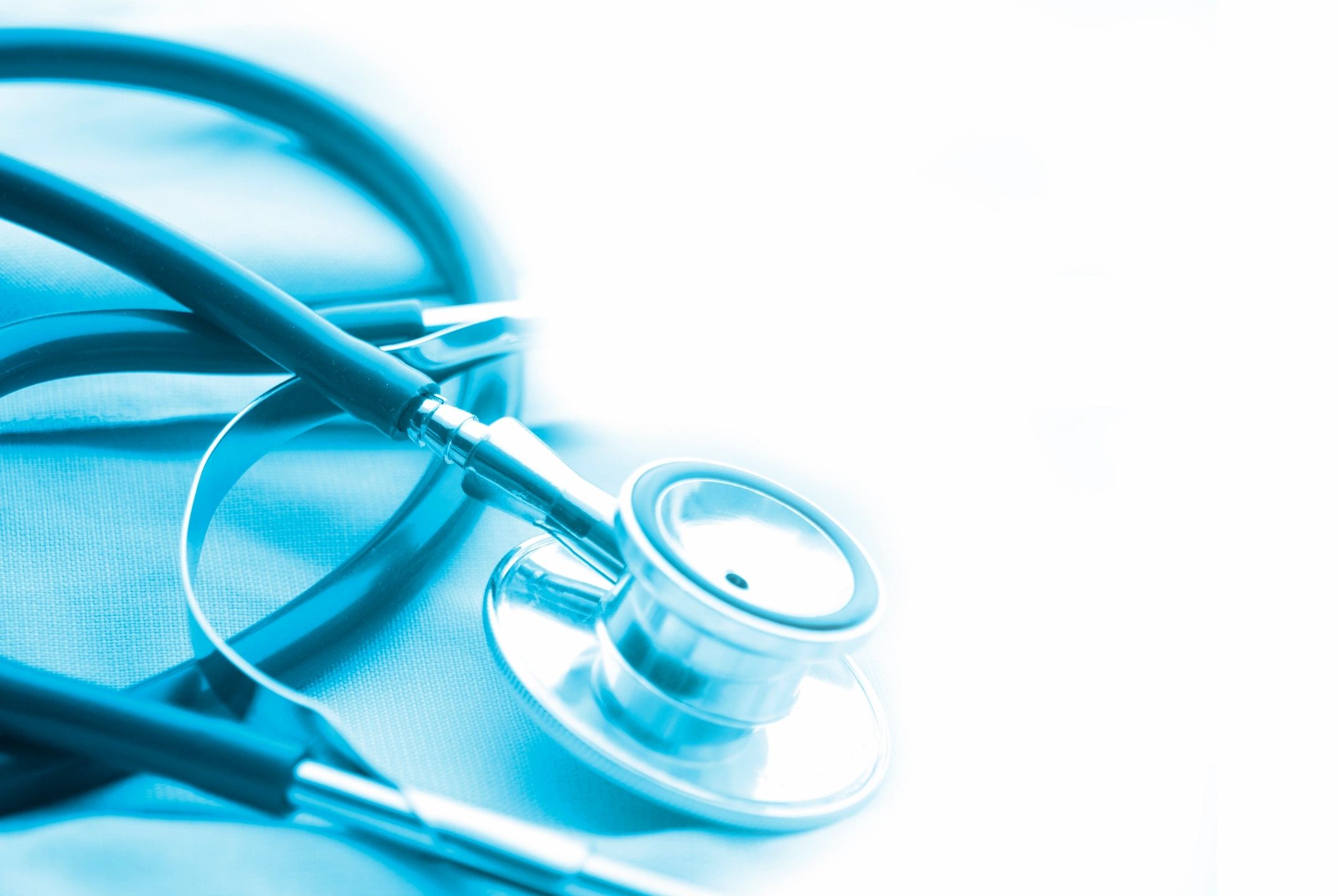 Close-up of a stethoscope on a blue medical cloth.