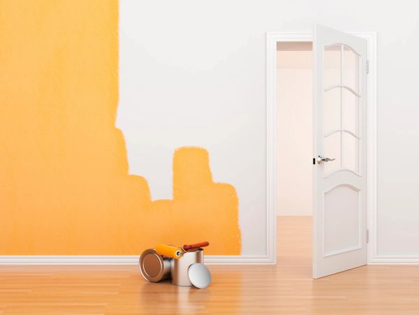 Partially painted wall with orange paint and open door in a room.