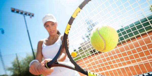 Girl playing tennis and hitting backhand
