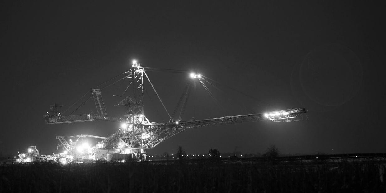 Large industrial mining machine illuminated at night.