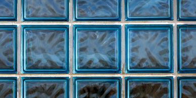 electric blue glass brick wall smooth to touch but bumpy inside. 