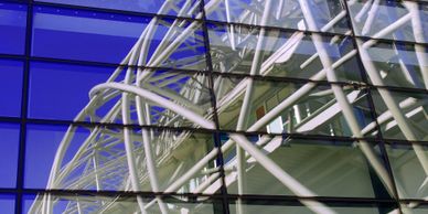 Building with glass windows reflecting industrial structure