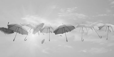 A row of umbrellas floating in the sky with clouds.