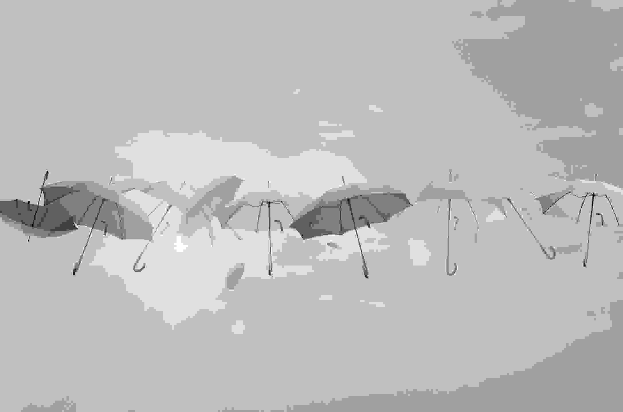 Image of colourful floating umbrellas. Represents protecting my clients from rainy days