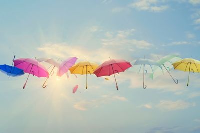 photo of multiple colorful umbrellas floating in the sky