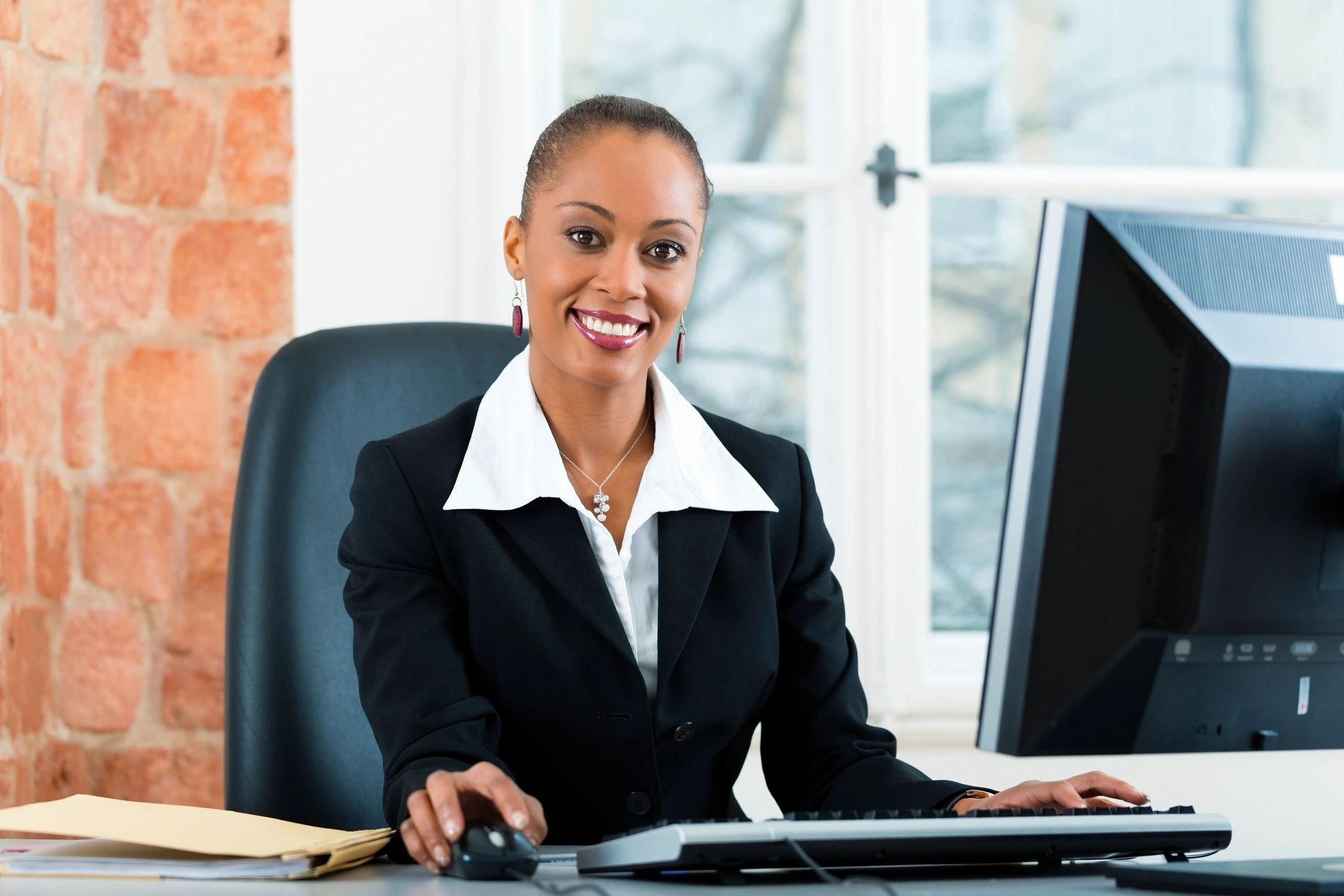 A smiling woman at a computer desk