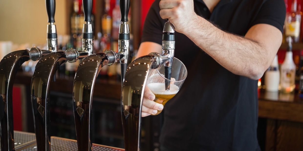 Bartender pouring adult beverages from a draft tap
