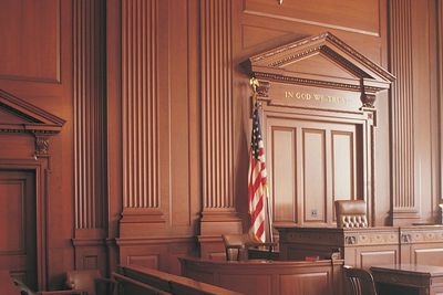 Empty courtroom with wooden decor and an American flag.