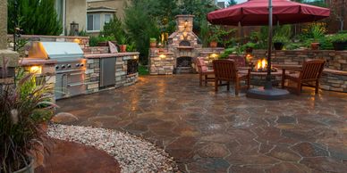 A spacious paver patio in the backyard features a full outdoor kitchen and dining area, perfect.
