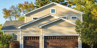 Suburban house with two wooden garage doors and a curved driveway.