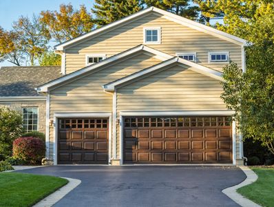 A modern house with a three-car garage and beige siding.