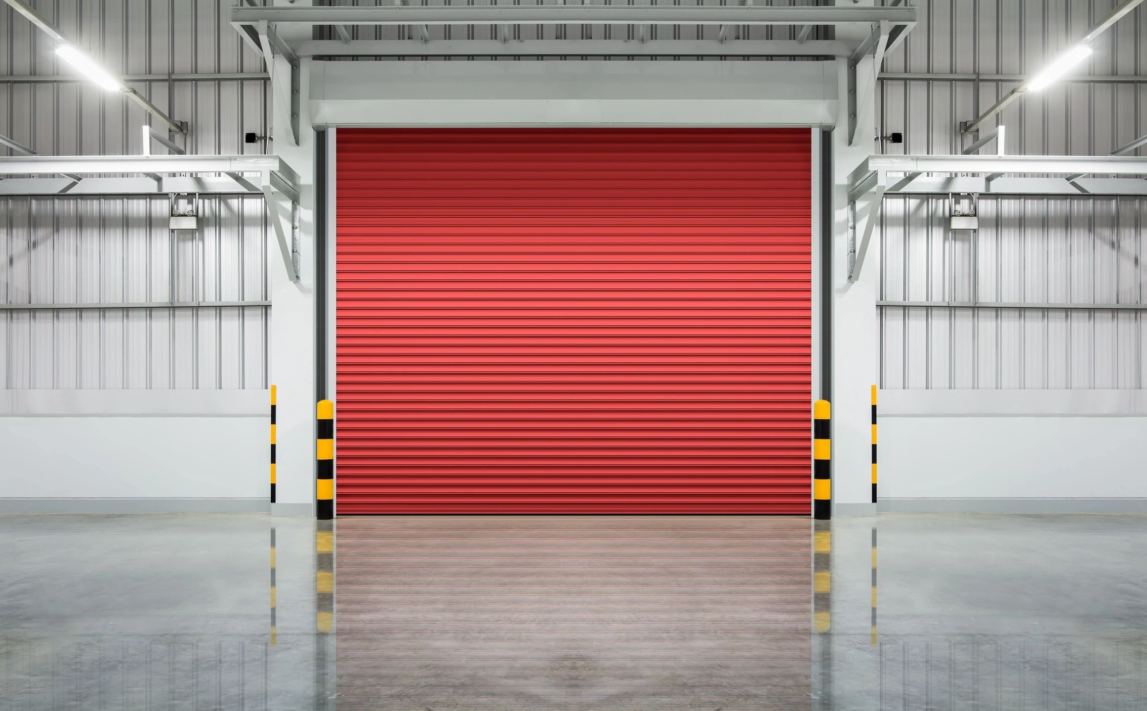 A closed red industrial roller door in a clean warehouse.